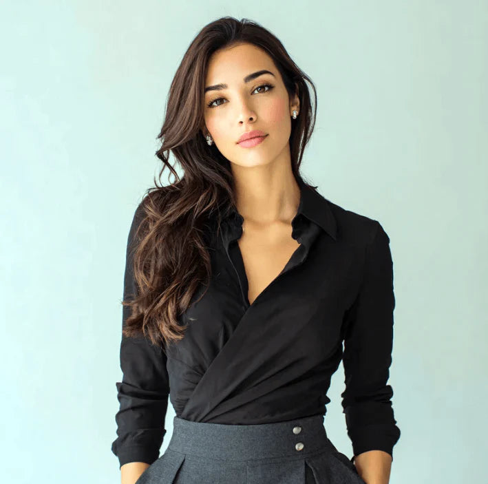 Modèle posant en chemise noire élégante avec cheveux longs et ondulés pour promouvoir un style chic.