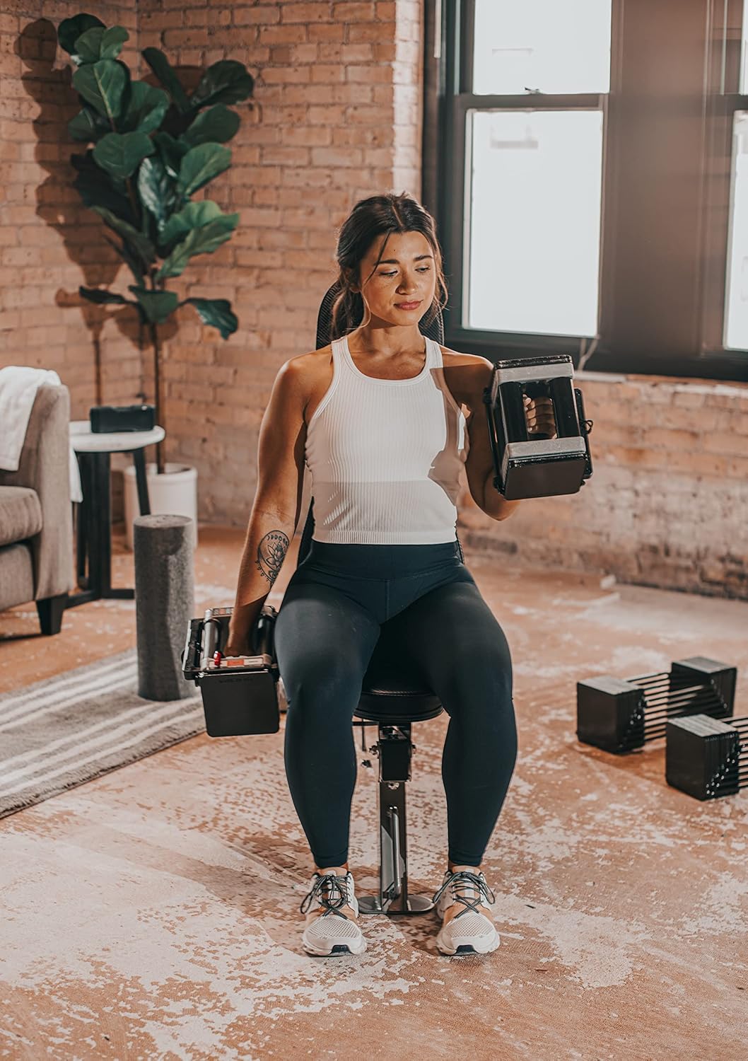 Femme utilisant les Autera FlexWeights™ pour un entraînement à domicile dans un espace moderne.